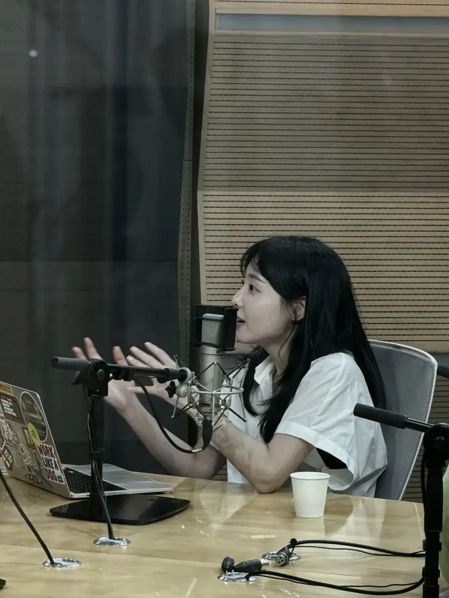 녹음 부스에서 마이크 앞에 앉아 이야기하는 김지원 강사