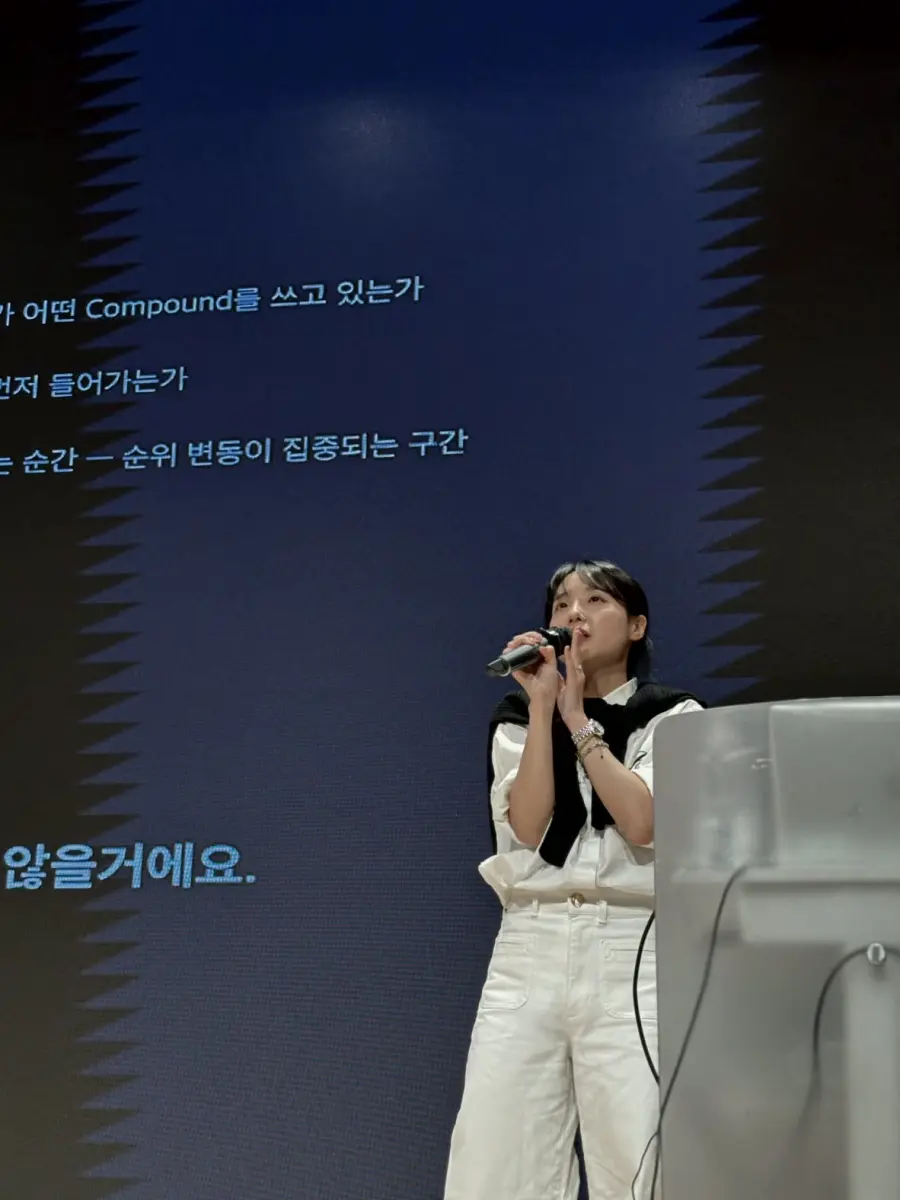 대형 스크린 앞 무대에서 마이크를 들고 강연하는 김지원 강사