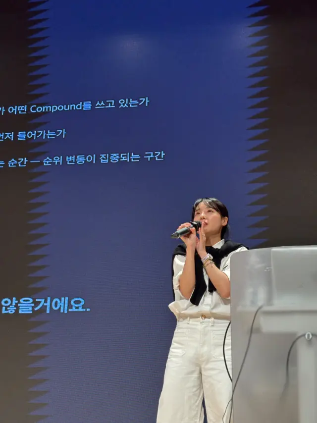 대형 스크린 앞 무대에서 마이크를 들고 강연하는 김지원 강사